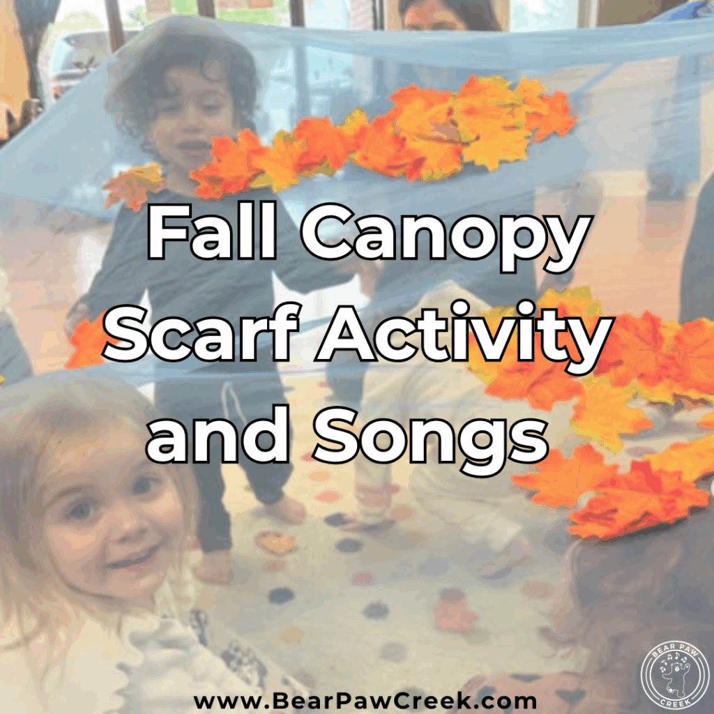 Kids underneath a canopy scarf with fall leaves on top.